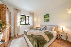 a white bedroom with a bed and a window at Сasa do Cedro in Colares +66 photos