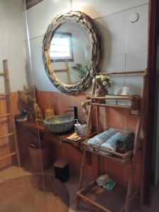 a bathroom with a mirror and a shelf with towels at Tidododesiles in Bouillante