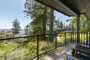 a balcony with a bench and a view of the ocean at Black Rock Oceanfront Resort in Ucluelet