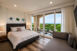 a bedroom with a bed and a couch and a balcony at Ocean Views, Rooftop Terrace & Resort Pools in Tamarindo