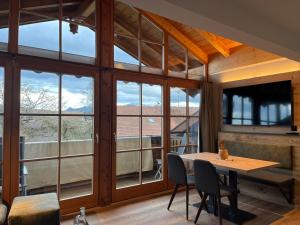a dining room with a table and some windows at Schererhof in Rimsting