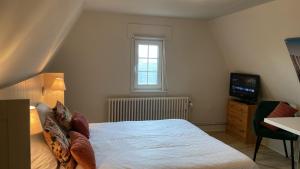 a small bedroom with a bed and a television at Logies La Dune Westende-Bad - Gratis parking in Middelkerke