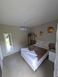 a bedroom with a large bed and a window at Pousada das Araras in Maceió +13 photos