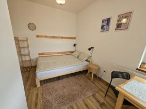 a small bedroom with a bed and a table at Roland Apartamenty in Świeradów-Zdrój +2 photos