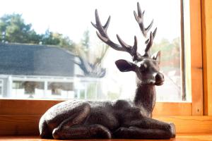 a statue of a reindeer sitting on a window sill at Strathspey Cottage in Carrbridge