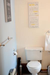 un baño con aseo y un letrero en la pared en Strathspey Cottage en Carrbridge