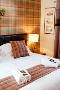 a hotel room with a bed with towels on it at Strathspey Cottage in Carrbridge
