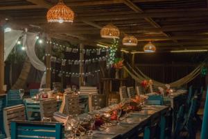 a long table in a room with lights and chandeliers at Blue Mango Beach Hotel in Guachaca