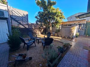 a patio with chairs and a table in a yard at Sol y Luna Hospedaje in Monte Grande