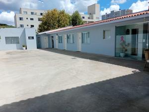 an empty parking lot next to a white building at Pousada Fernanda in Guarapuava