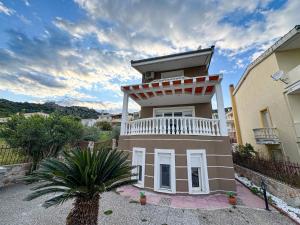 a house with a balcony on top of it at Maison De La Mer in Paleo Tsifliki