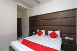 a bedroom with a large bed with red pillows at Hotel O South Fern in Kolkata