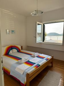 a bedroom with a rainbow bed with a window at 2 bed Comfy Gem: Functional, Ideal Location, Steps to the Beach in Blace