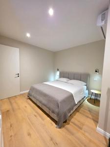 a bedroom with a large bed and a wooden floor at JACUZZI LIVING TIRANA center 1 in Tirana