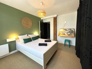 a bedroom with a large white bed in a room at L'Héritage, Loft design et pierre in Dol-de-Bretagne