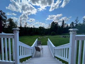 a deck with two chairs sitting on top of it at Barron Brook Inn in Whitefield