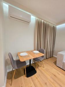 a room with a table and chairs and a bed at JACUZZI LIVING TIRANA center 1 in Tirana