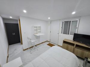 a bedroom with a bed and a desk and a television at Boeing AL Q1 in Moreira