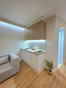 a white kitchen with a sink and a couch at JACUZZI LIVING TIRANA center 1 in Tirana +17 photos