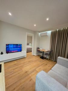 a living room with a couch and a tv and a table at JACUZZI LIVING TIRANA center 1 in Tirana