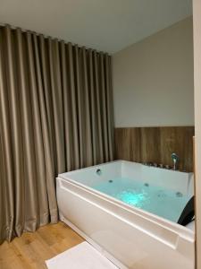 a large bath tub in a bathroom with curtains at JACUZZI LIVING TIRANA center 1 in Tirana