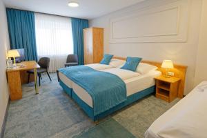 a hotel room with a bed and a desk at Friends Hotel Kerpen in Kerpen