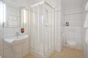 a bathroom with a shower and a sink and a toilet at Friends Hotel Kerpen in Kerpen +46 photos