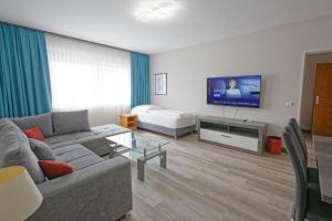 a living room with a couch and a flat screen tv at Friends Hotel Kerpen in Kerpen
