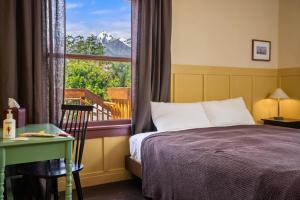 a bedroom with a bed and a window with a mountain view at Winnedumah Hotel in Independence