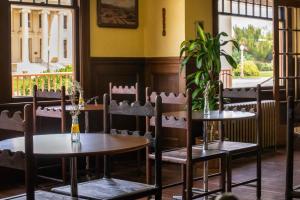 a restaurant with two tables and chairs and a plant at Winnedumah Hotel in Independence
