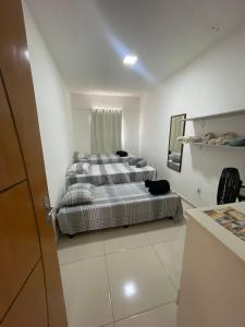 a bedroom with a bed in a white room at Pousada Aconchego in São Mateus