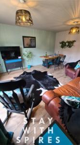 a living room with a cow rug on the floor at The Farrier's recently refurbished 3 bedroom comfy and cosy bolt hole close to Cannock town centre in Hednesford