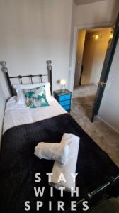 a bedroom with a bed with a black and white blanket at The Farrier's recently refurbished 3 bedroom comfy and cosy bolt hole close to Cannock town centre in Hednesford