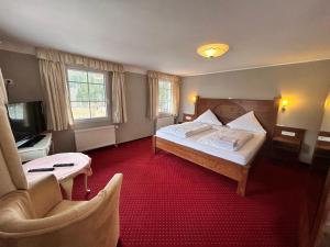 a hotel room with a bed and a chair at Gasthaus Hotel Löffelschmiede in Hinterzarten