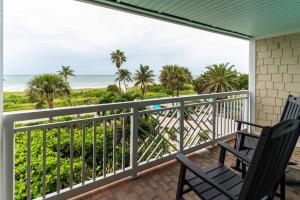 a balcony with two chairs and a view of the beach at Tween Waters Island Resort & Spa in Captiva