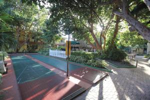 a tennis court in a park with trees at Sea Gardens Resort Studio Suite in Pompano Beach