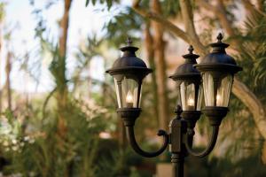 two black street lights with trees in the background at Sea Gardens Resort Studio Suite in Pompano Beach