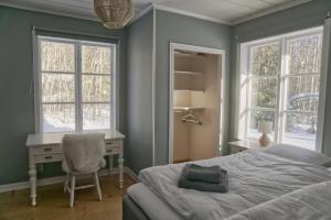 a bedroom with a bed and a desk and windows at Cozy forest cabin in Vik +25 photos