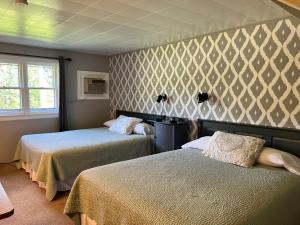 a hotel room with two beds and a window at Barron Brook Inn in Whitefield