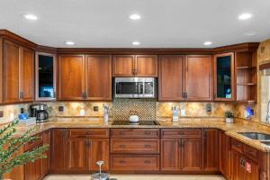 a kitchen with wooden cabinets and a microwave at 1480 W Riviera Dr in Merritt Island
