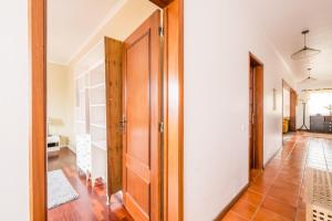 a hallway with a wooden door and a tile floor at Ben House, private parking in Ponta Delgada