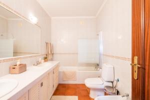 a bathroom with a toilet and a sink and a tub at Ben House, private parking in Ponta Delgada