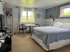 a bedroom with a bed and a table and a window at Barron Brook Inn in Whitefield +26 photos