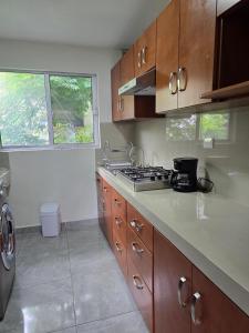 a kitchen with wooden cabinets and a stove top oven at Cumbre Guesthouse in Monterrey +28 photos