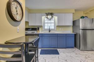 a kitchen with blue cabinets and a clock on the wall at Steps to Beach! North Myrtle Beach (Cherry Grove) in Myrtle Beach