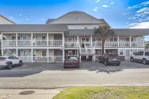 a large building with cars parked in a parking lot at Steps to Beach! North Myrtle Beach (Cherry Grove) in Myrtle Beach