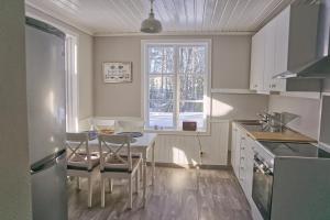 a kitchen with a table and chairs and a window at Cozy forest cabin in Vik