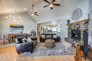 a living room with leather furniture and a stone fireplace at Hot Tub & Seasonal Pool: Remarkable Yakima Getaway in Yakima