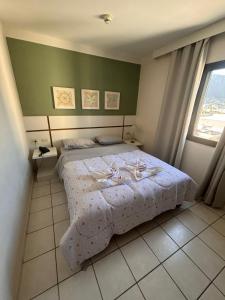 a bedroom with a bed and a large window at Flat a Beira Mar in Caraguatatuba