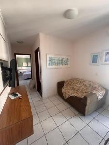 a bedroom with a bed and a tv in it at Flat a Beira Mar in Caraguatatuba